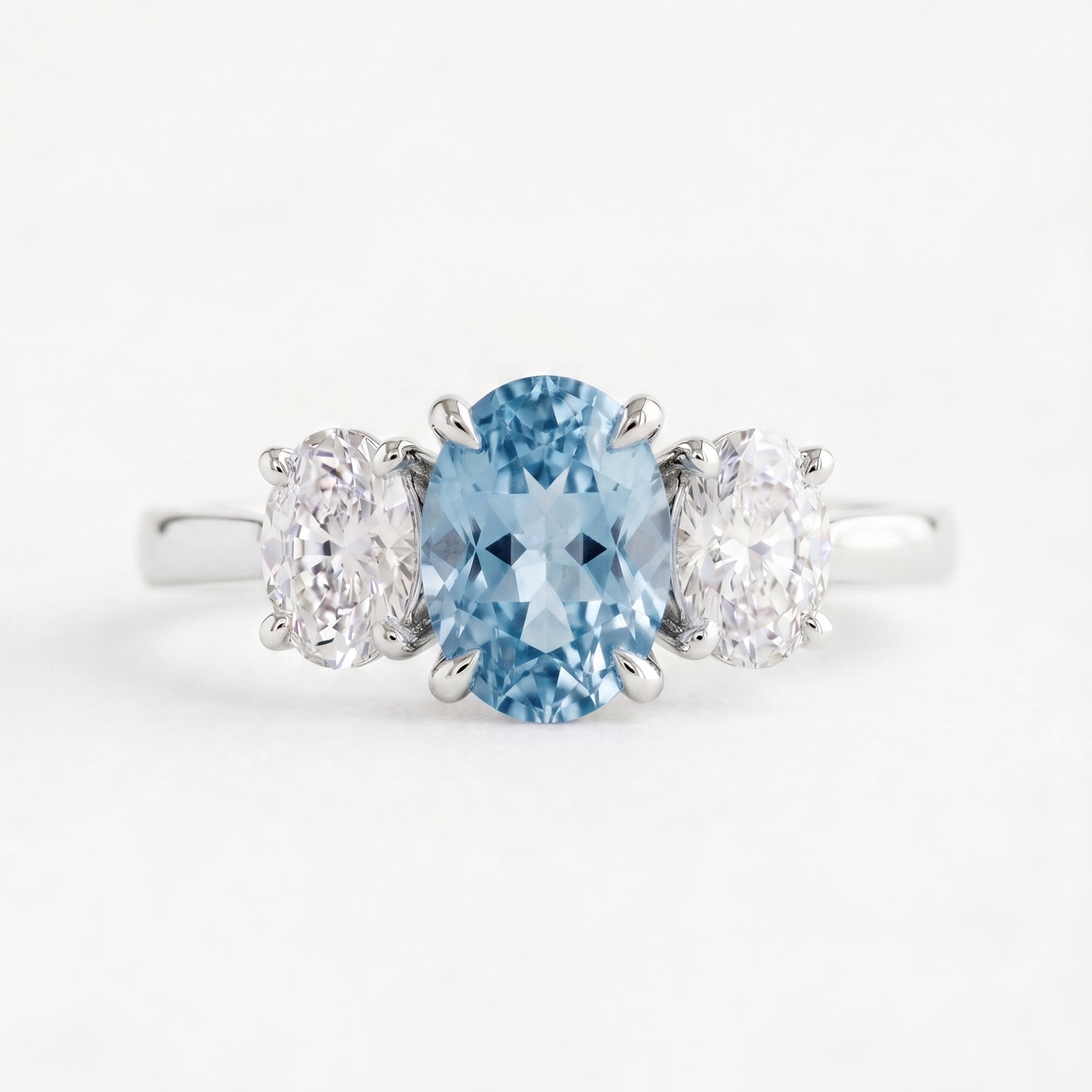 Ring with a blue gemstone and two smaller stones on a white background