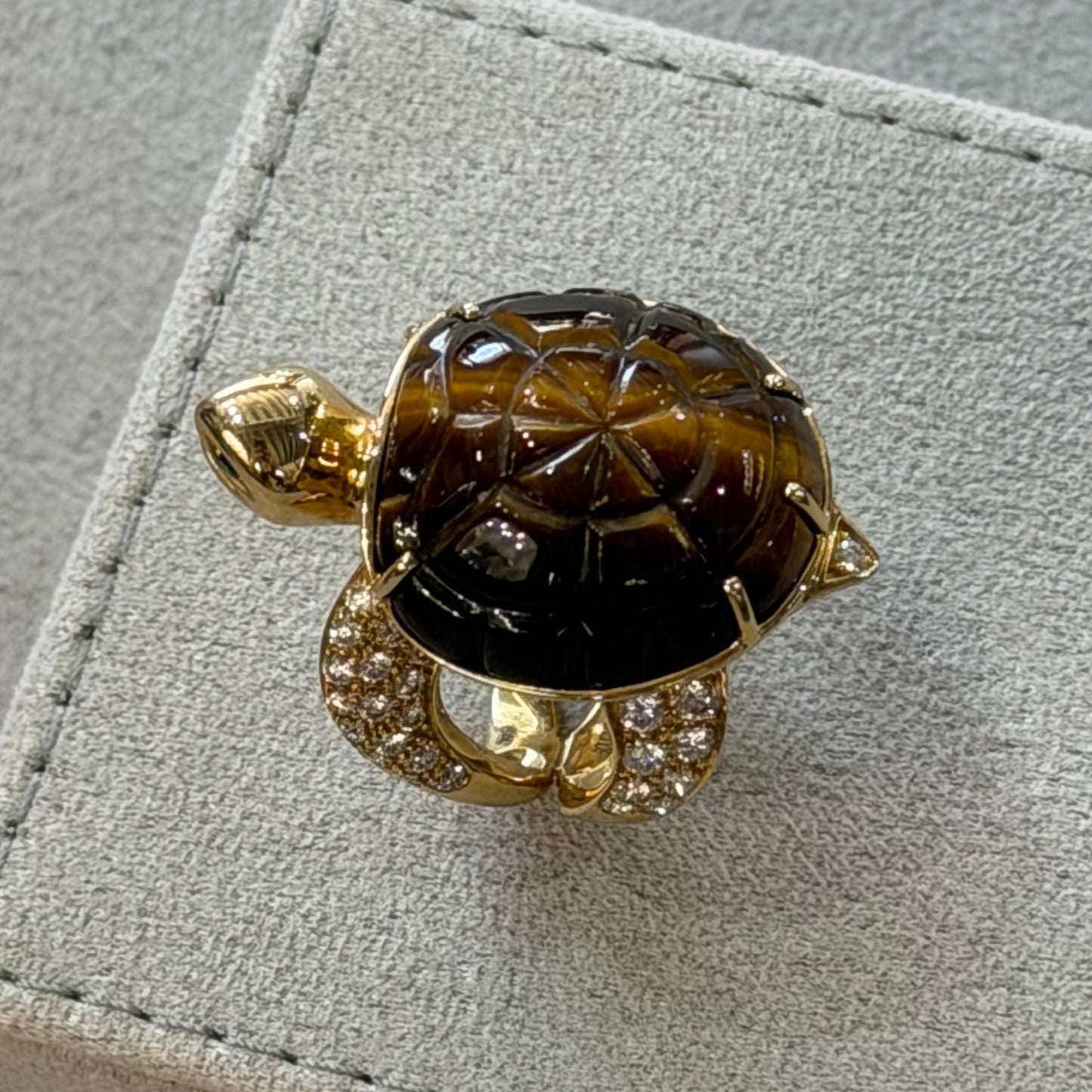 Gold ring with a large gemstone on a gray surface