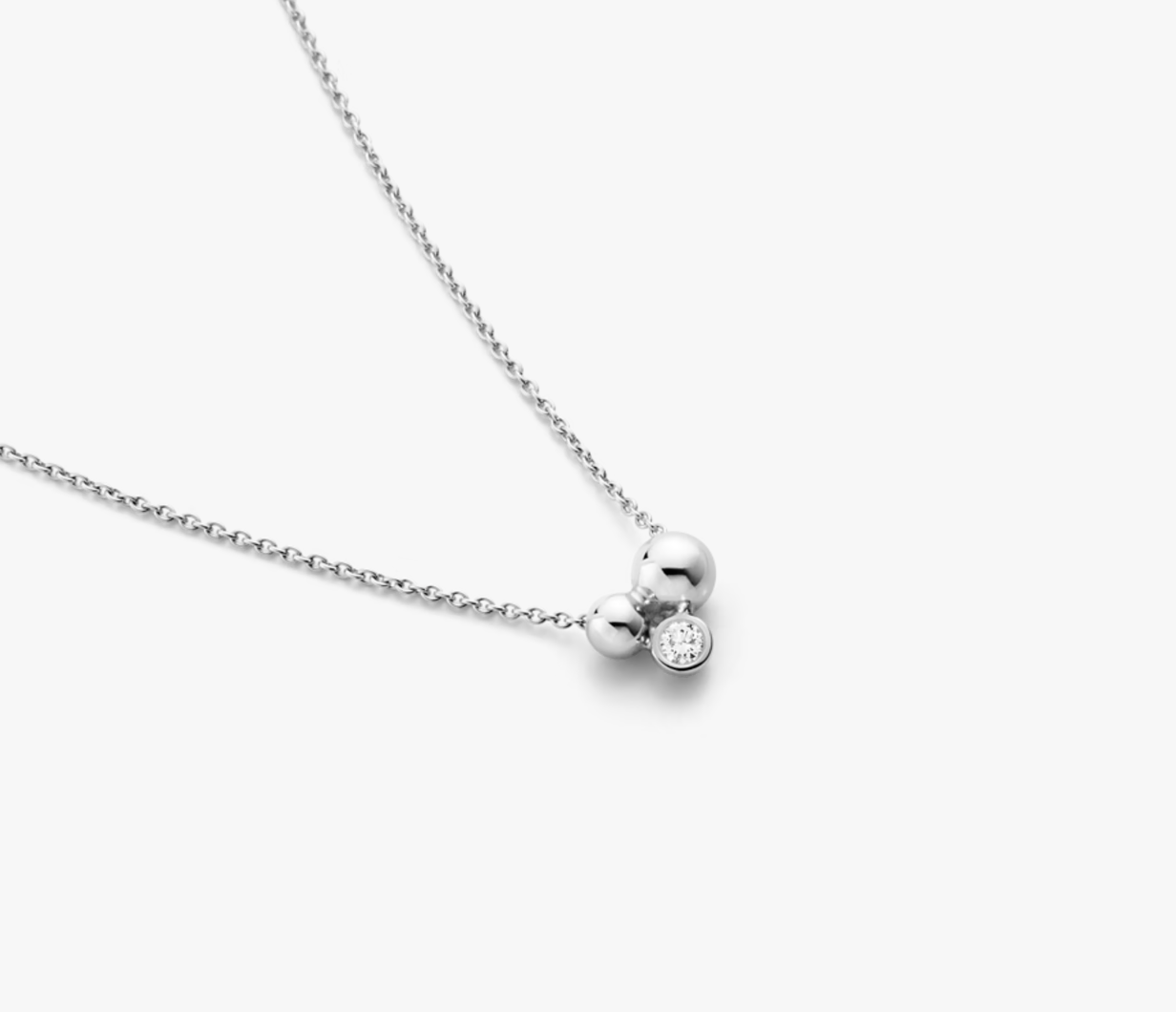 Silver necklace with two round pendants on a white background