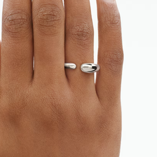 Silver ring on a person's finger with a plain background