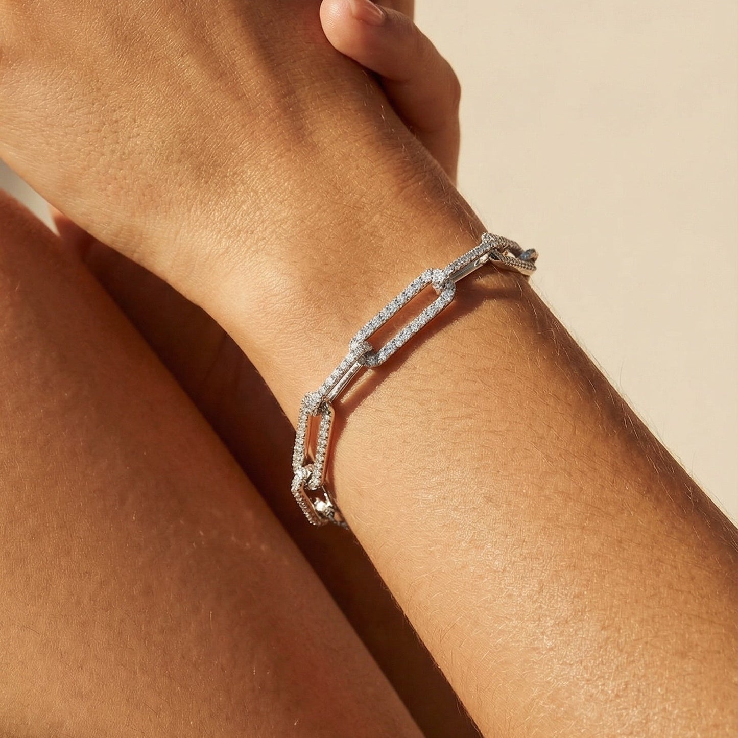 image of models hand with a white gold white diamond chain link bracelet