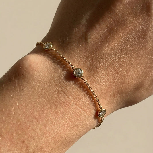 rose gold three white diamond chain bracelet on a models hand 