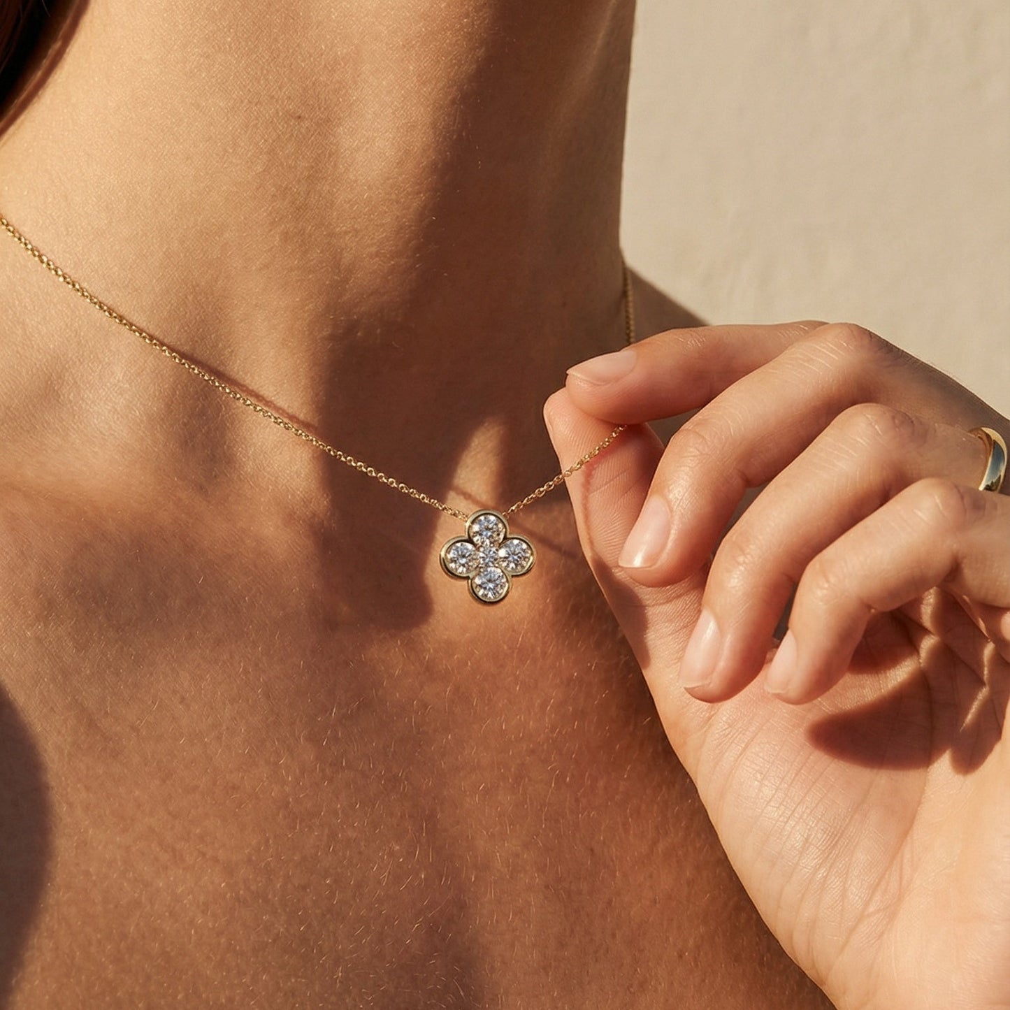 close up image of a model wearing a flower shape yellow gold diamond necklace 