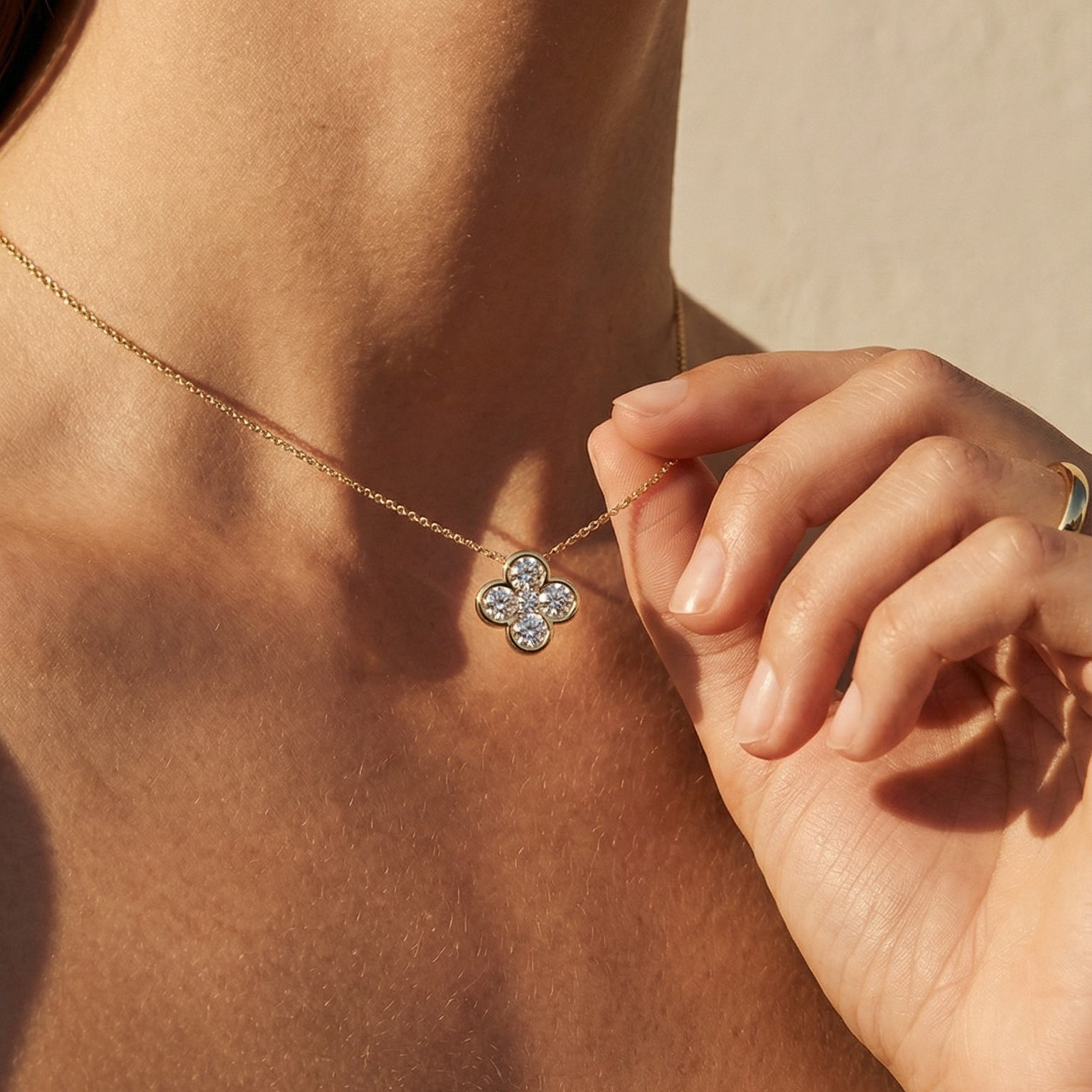 close up image of a model wearing a flower shape yellow gold diamond necklace 