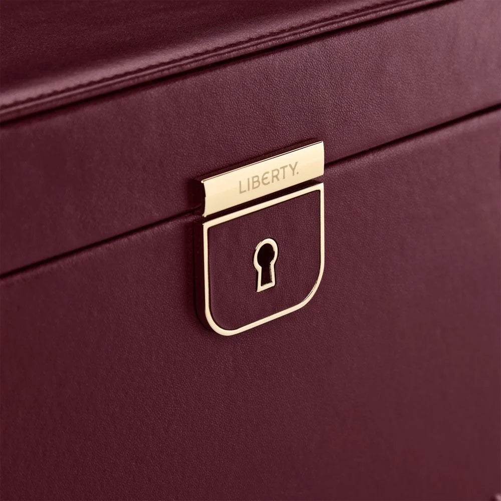 Close-up of a maroon jewelry box with a gold lock emblem and 'LIBERTY' branding.