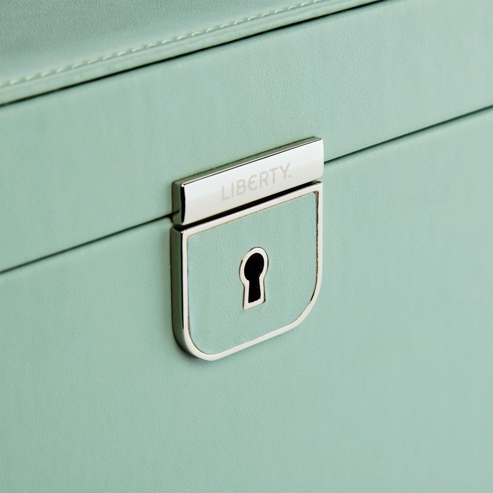 Close-up of a light green cabinet with a silver lock featuring the brand 'Liberty'.