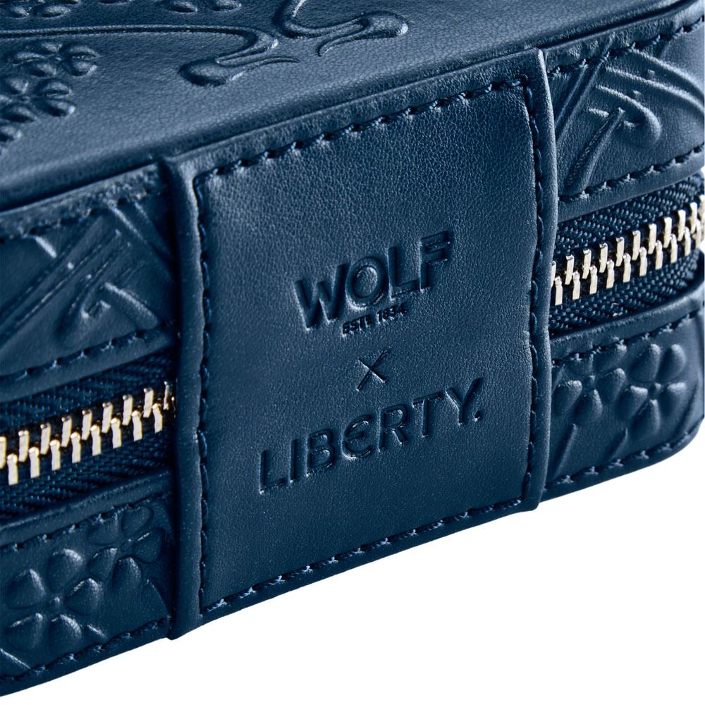 Close-up of a blue leather wallet with 'Wolf & Liberty' branding.