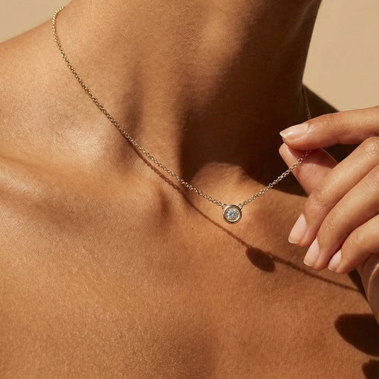 Necklace with a pendant worn by a person against a neutral background