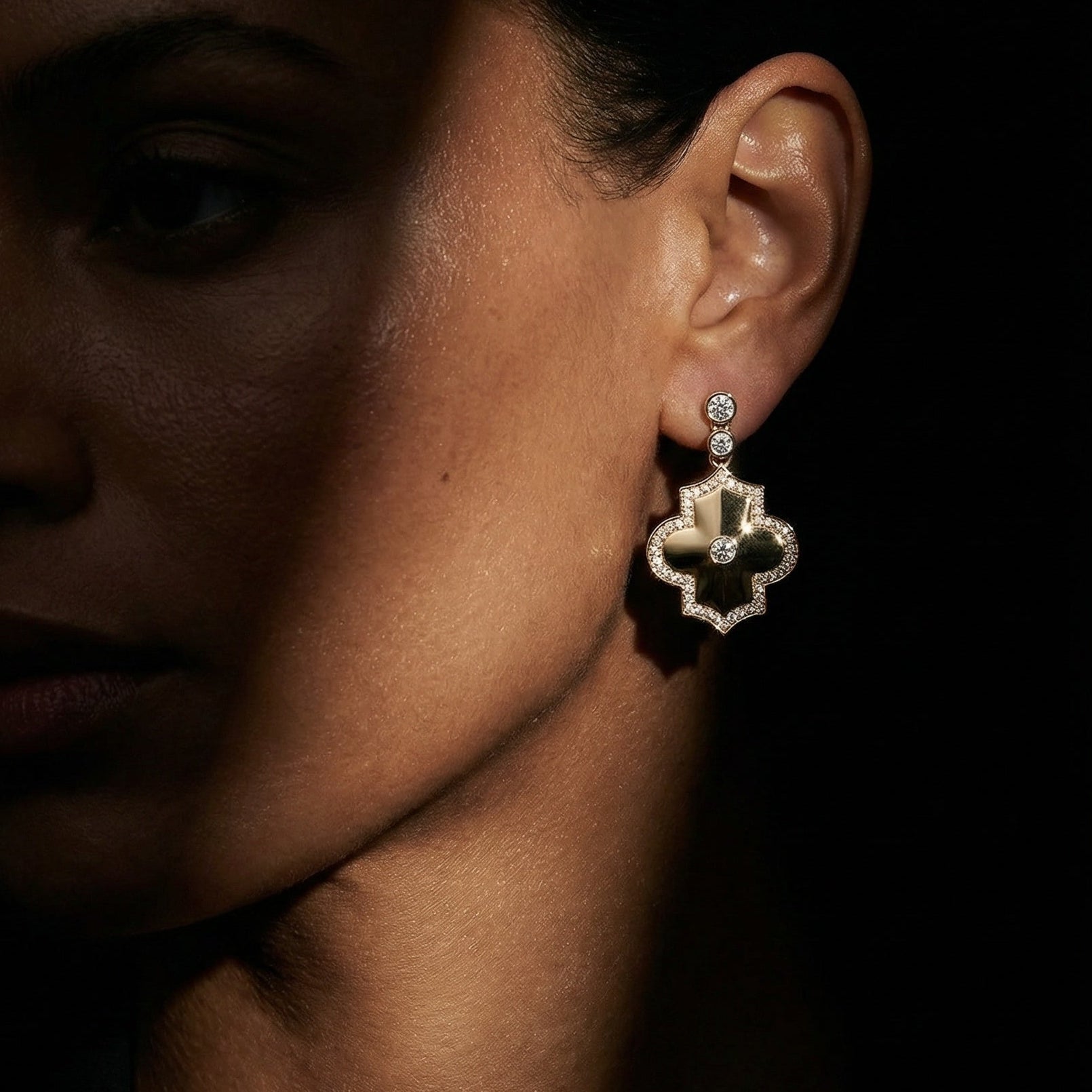 Yellow gold white diamond drop earrings in a geometrical shape on a model 