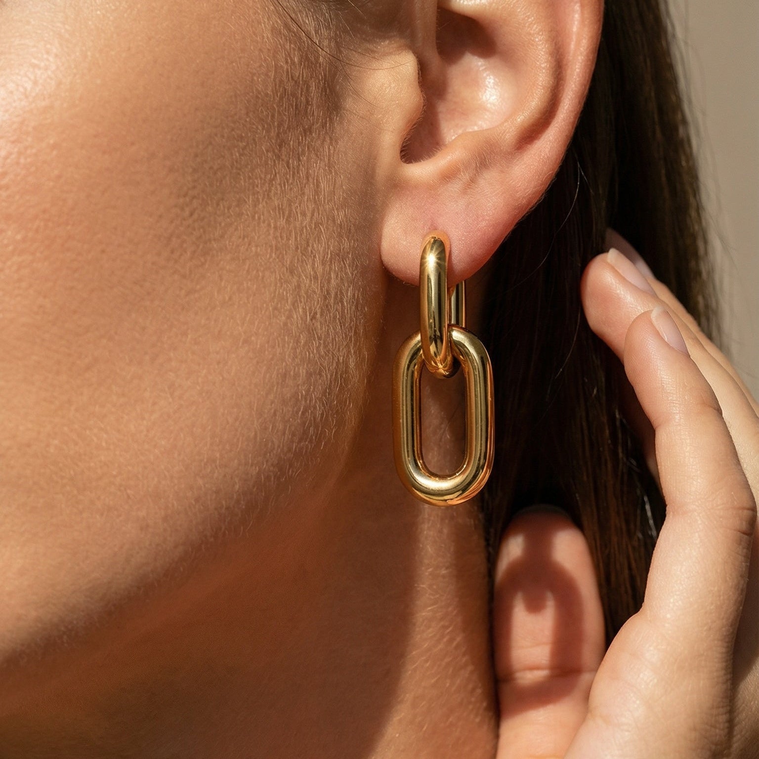 yellow gold drop double hoop earrings shown on a model 