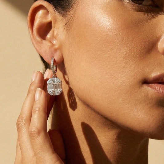 white gold white diamonds illusion setting drop earrings worn by a model 