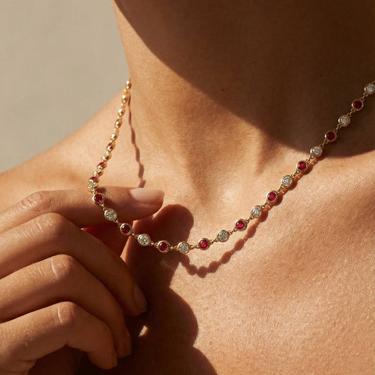 Necklace with multicolored beads worn by a person against a neutral background