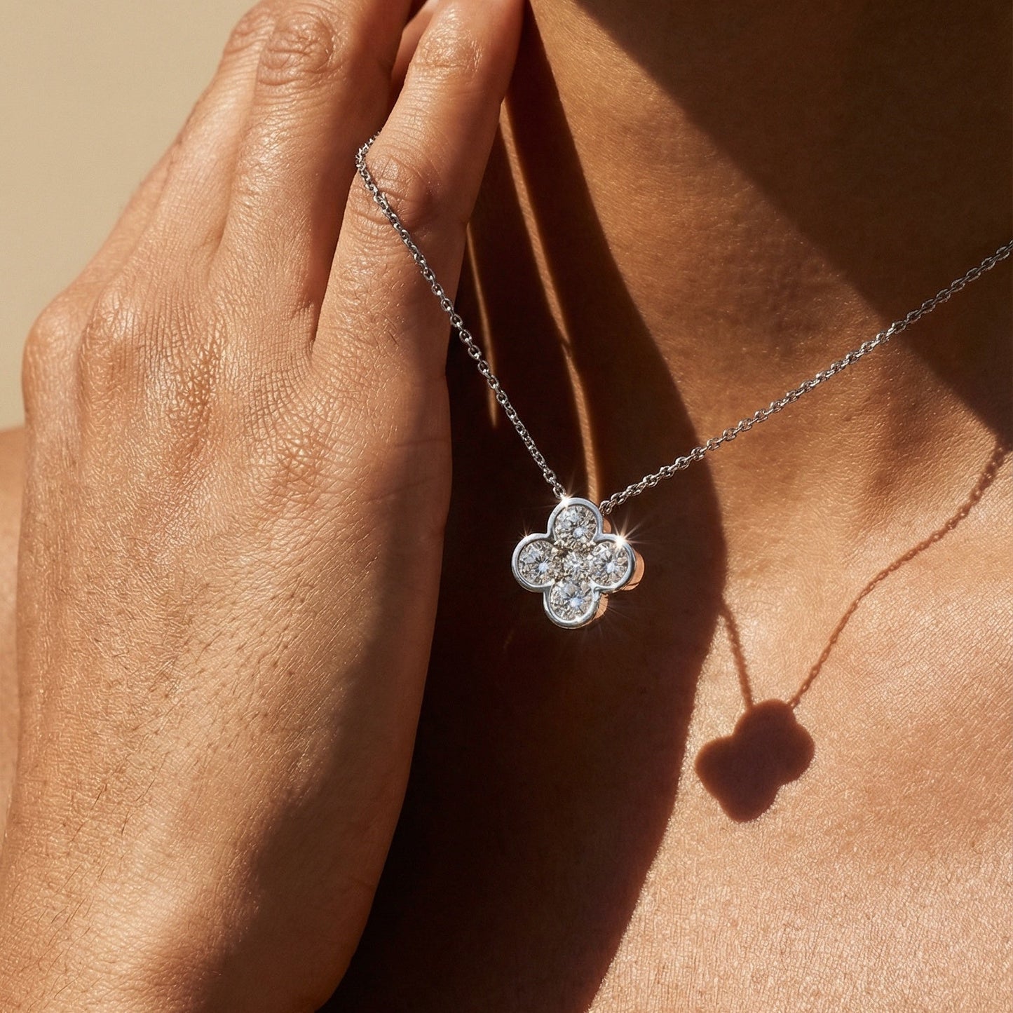 Close-up of a necklace with a clover-shaped pendant on a person's neck.