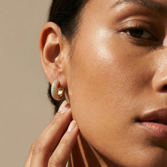 model wearing yellow gold small hoops in full pave diamond 