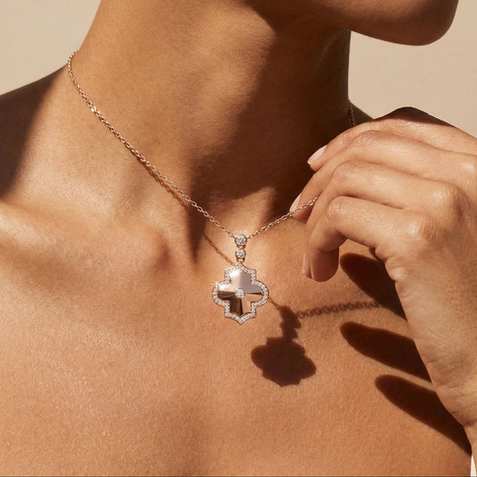 Necklace with a diamond pendant worn by a person against a neutral background