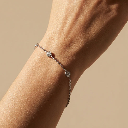 close up of a models hand wearing three diamond chain bracelet in white gold 