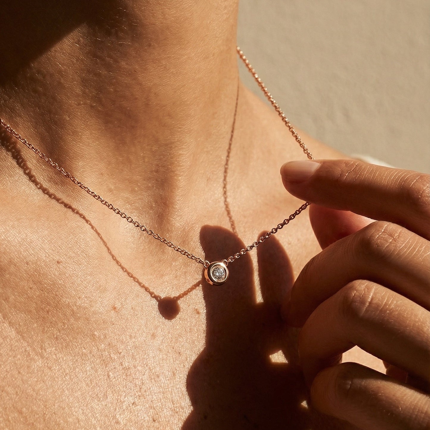 model wearing a rose gold white diamond single stone pendant 
