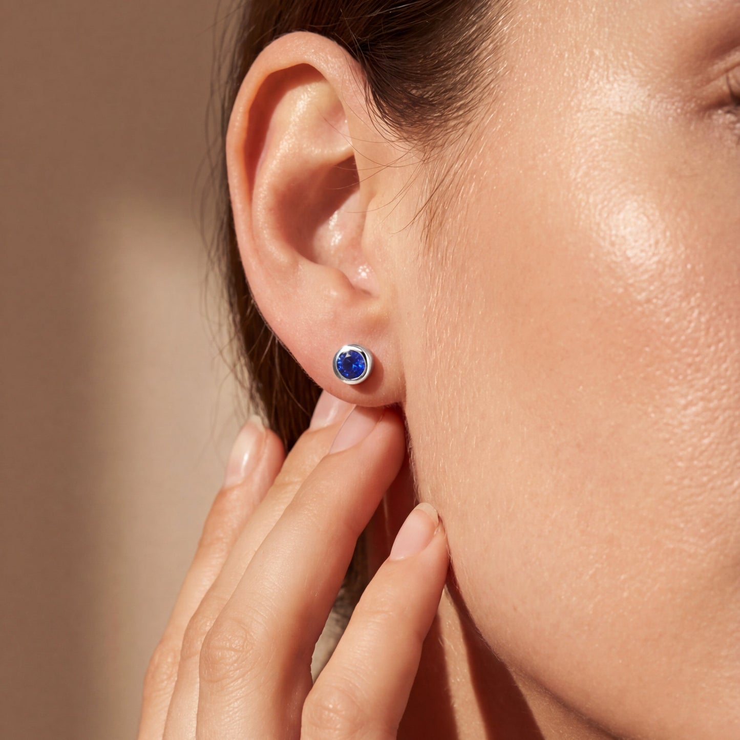 model wearing white gold round blue sapphire earring studs 