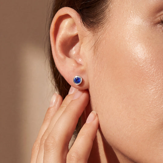 model wearing white gold round blue sapphire earring studs 