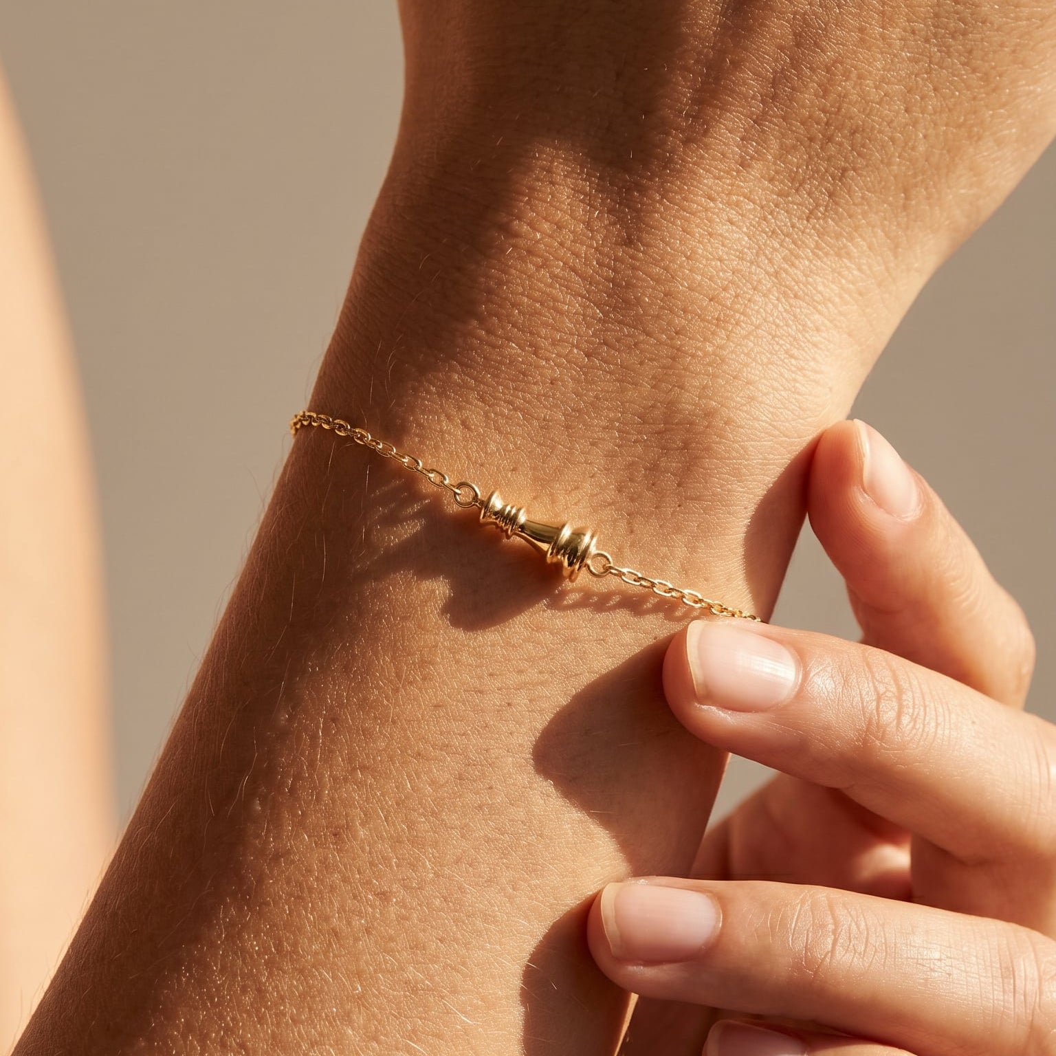 Ksenia Mirella Jewellery Queen Collection Chain Bracelet Close-up of a hand wearing a gold bracelet on a neutral background