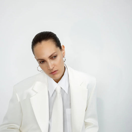 model wearing The Georg Jensen Reflect Large Hoops in Sterling Silver. A bold, sculptural twist on a classic in stock for fast delivery from Peter Ungar.