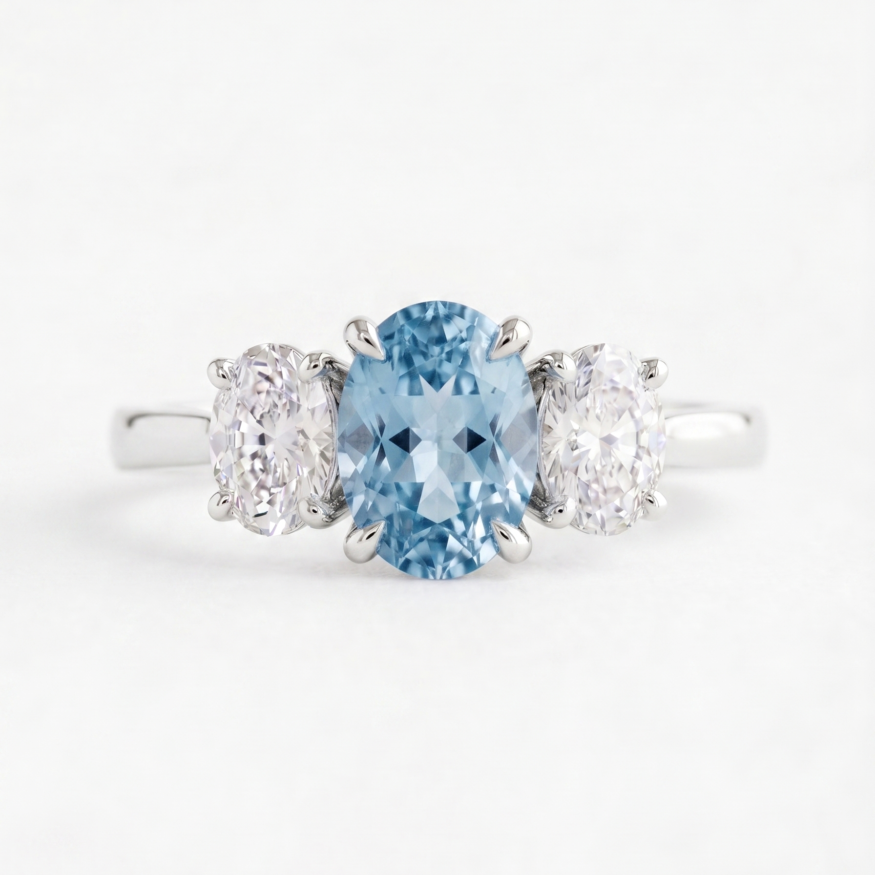 Ring with a blue gemstone and two smaller stones on a white background