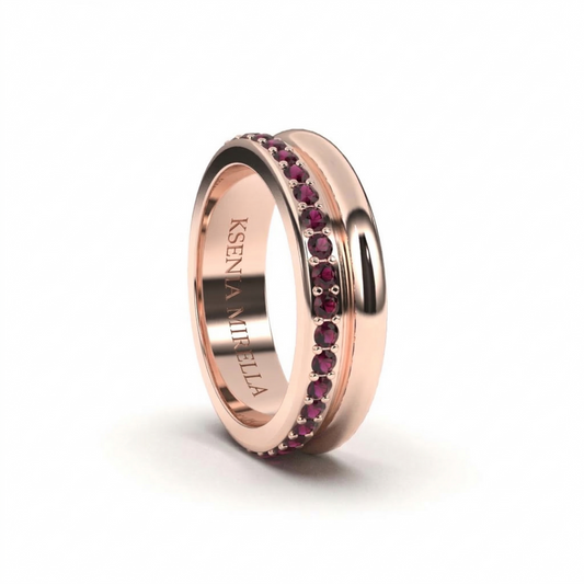 Rose gold ring with embedded red gemstones on a white background