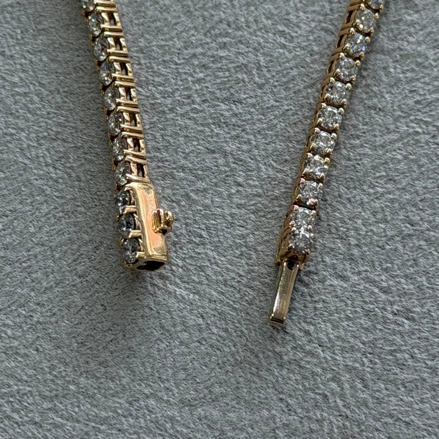 Gold chain with diamond accents on a gray textured background
