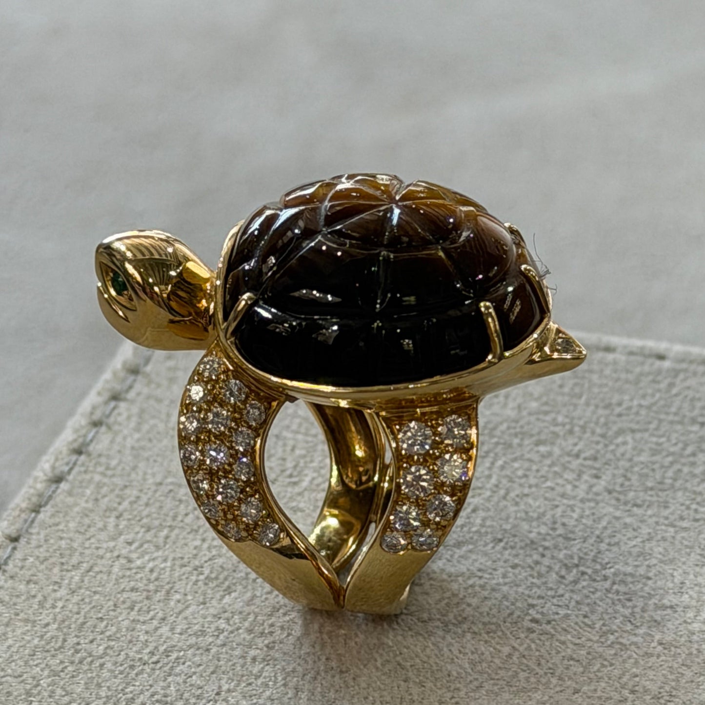 Gold ring with a large black gemstone on a textured surface