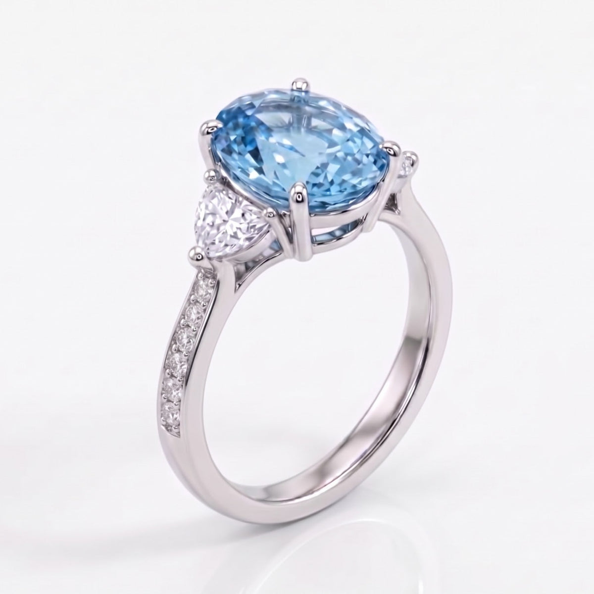 A silver-toned ring featuring a large oval light blue gemstone in a prong setting, with small clear stones along the band, shown on a clean white background.