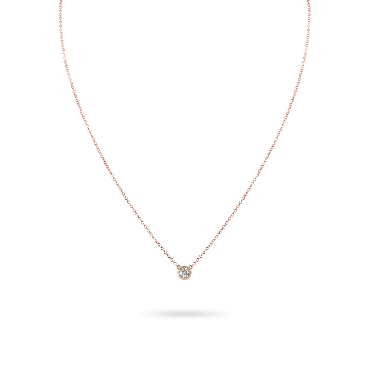 Rose gold necklace with a small diamond pendant on a white background