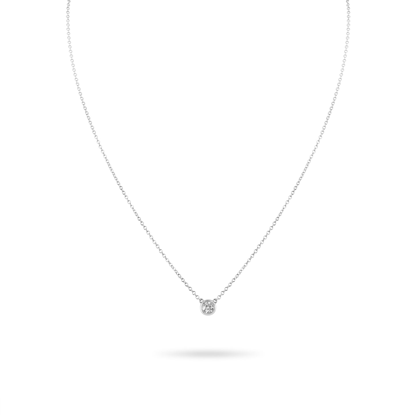 Delicate silver necklace with a small round pendant on a white background