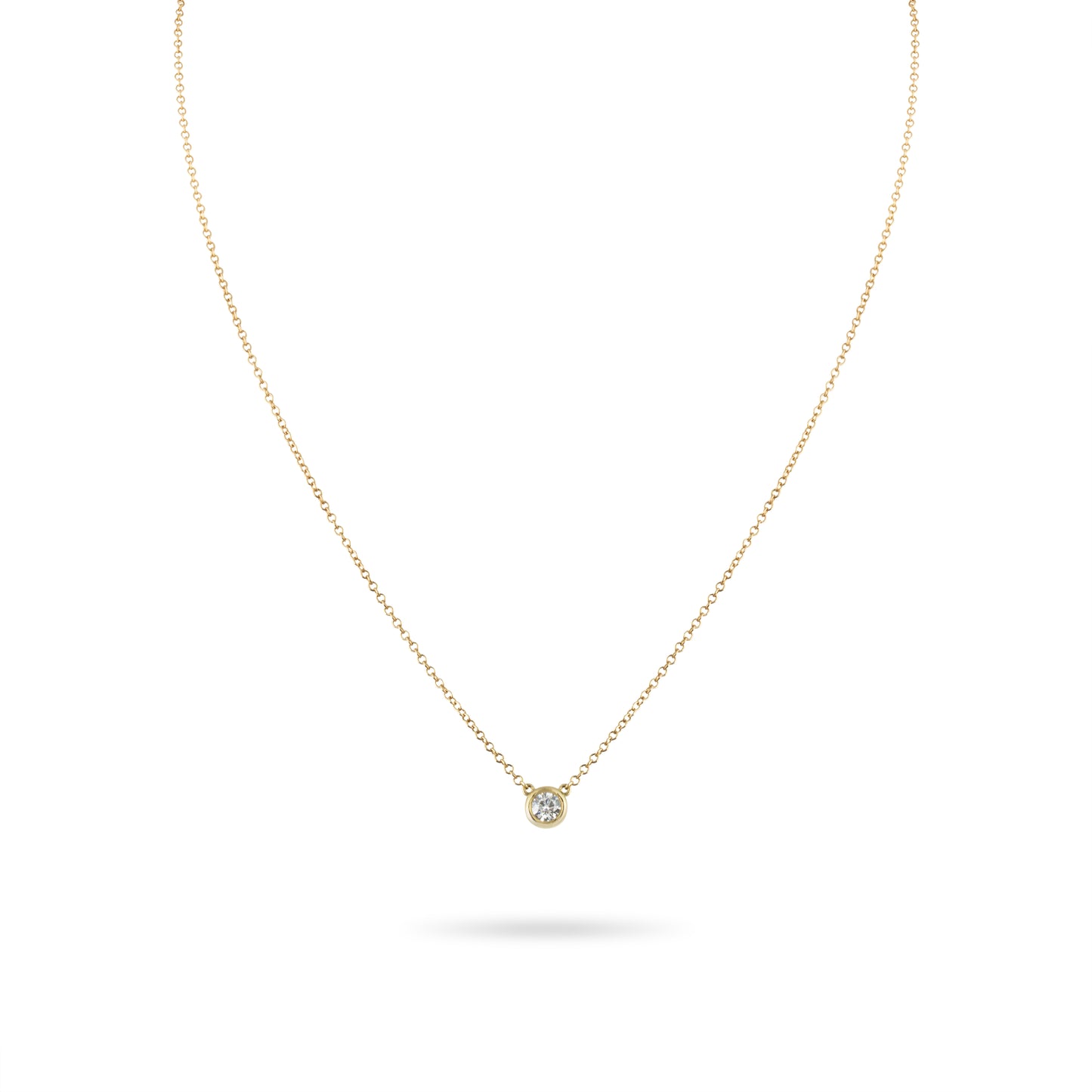 Gold necklace with a small diamond pendant on a white background