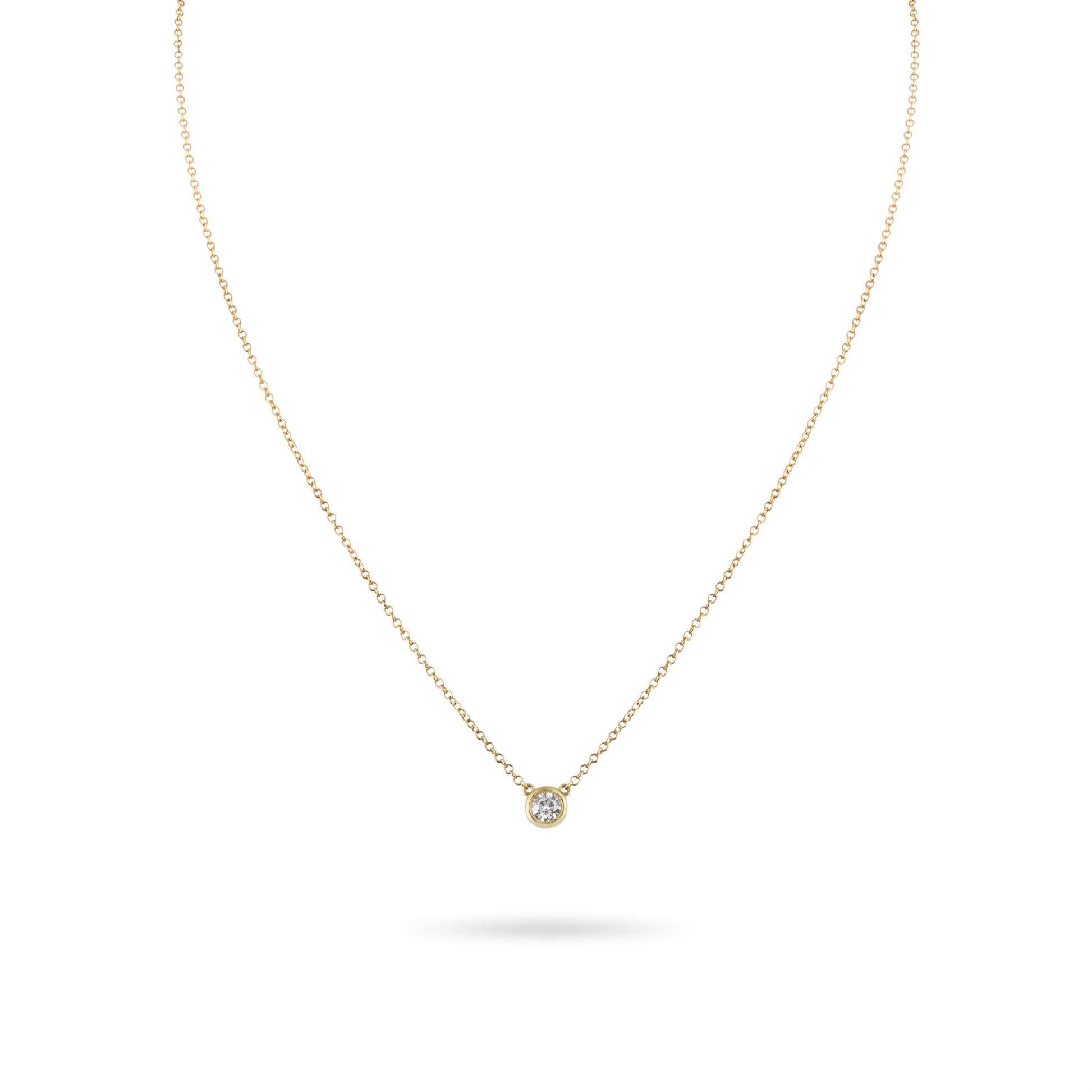 Gold necklace with a small diamond pendant on a white background
