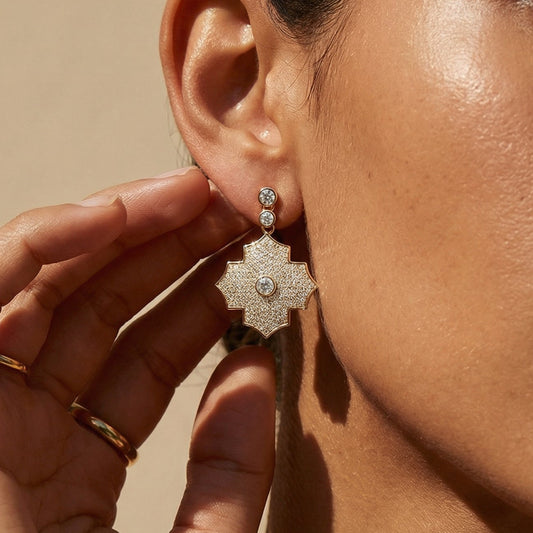 Close-up of a woman wearing a floral earring with a beige background