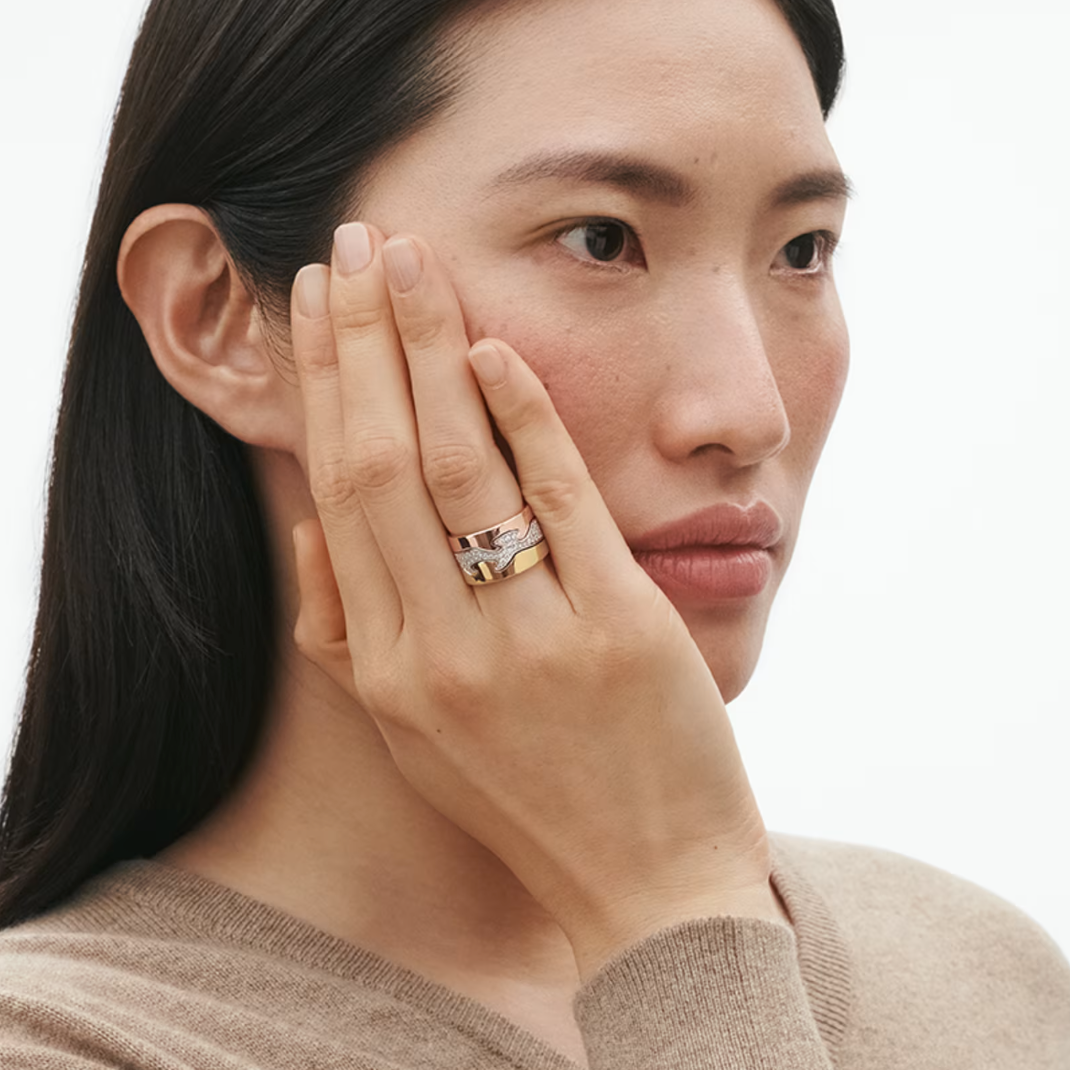 Woman wearing a ring on her finger with a neutral background