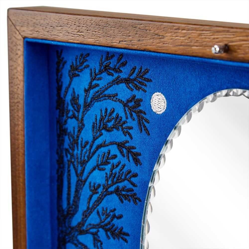 Wooden frame with blue interior and decorative black pattern, featuring a silver button.