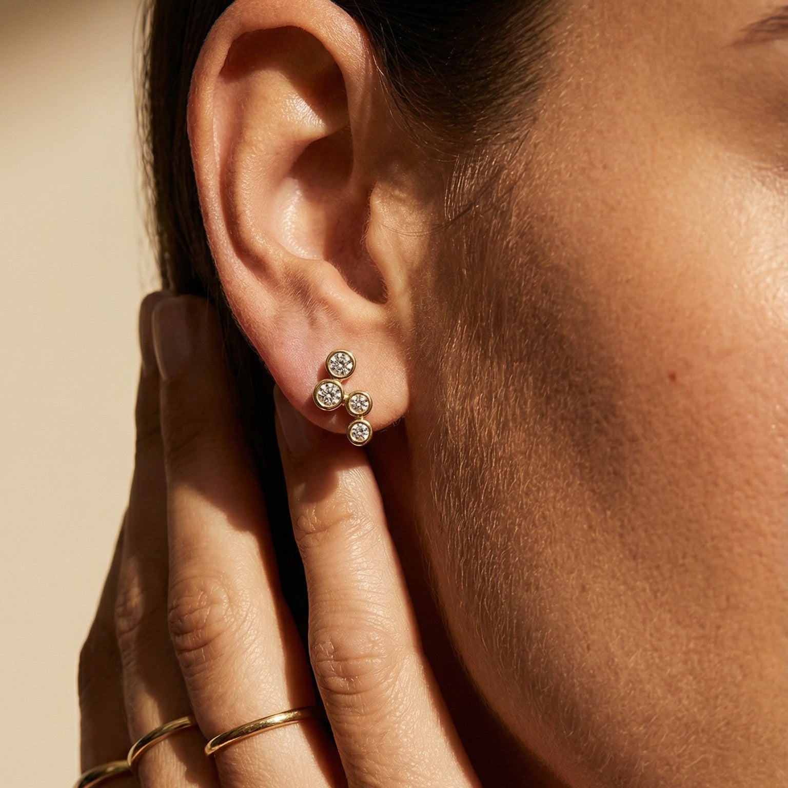 model wearing 4 round diamond drop stud in yellow gold 