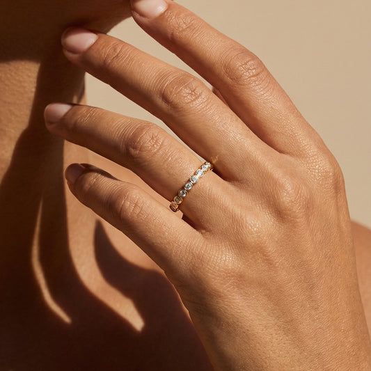 Close-up of a hand wearing a ring with a neutral background