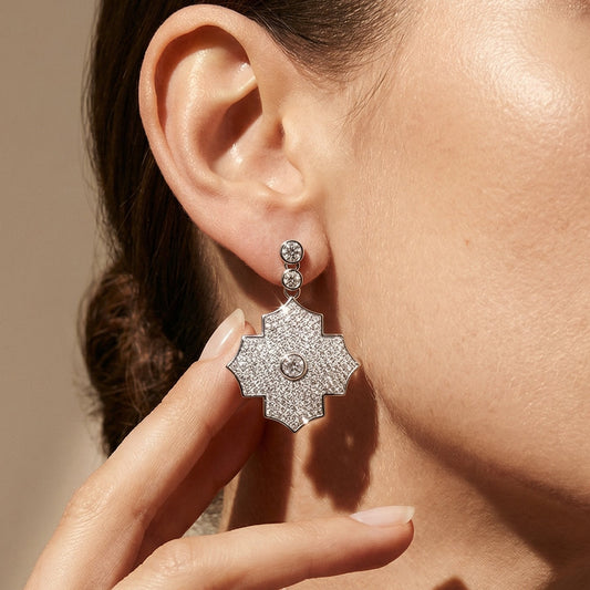 Close-up of a person wearing a star-shaped diamond earring with a neutral background