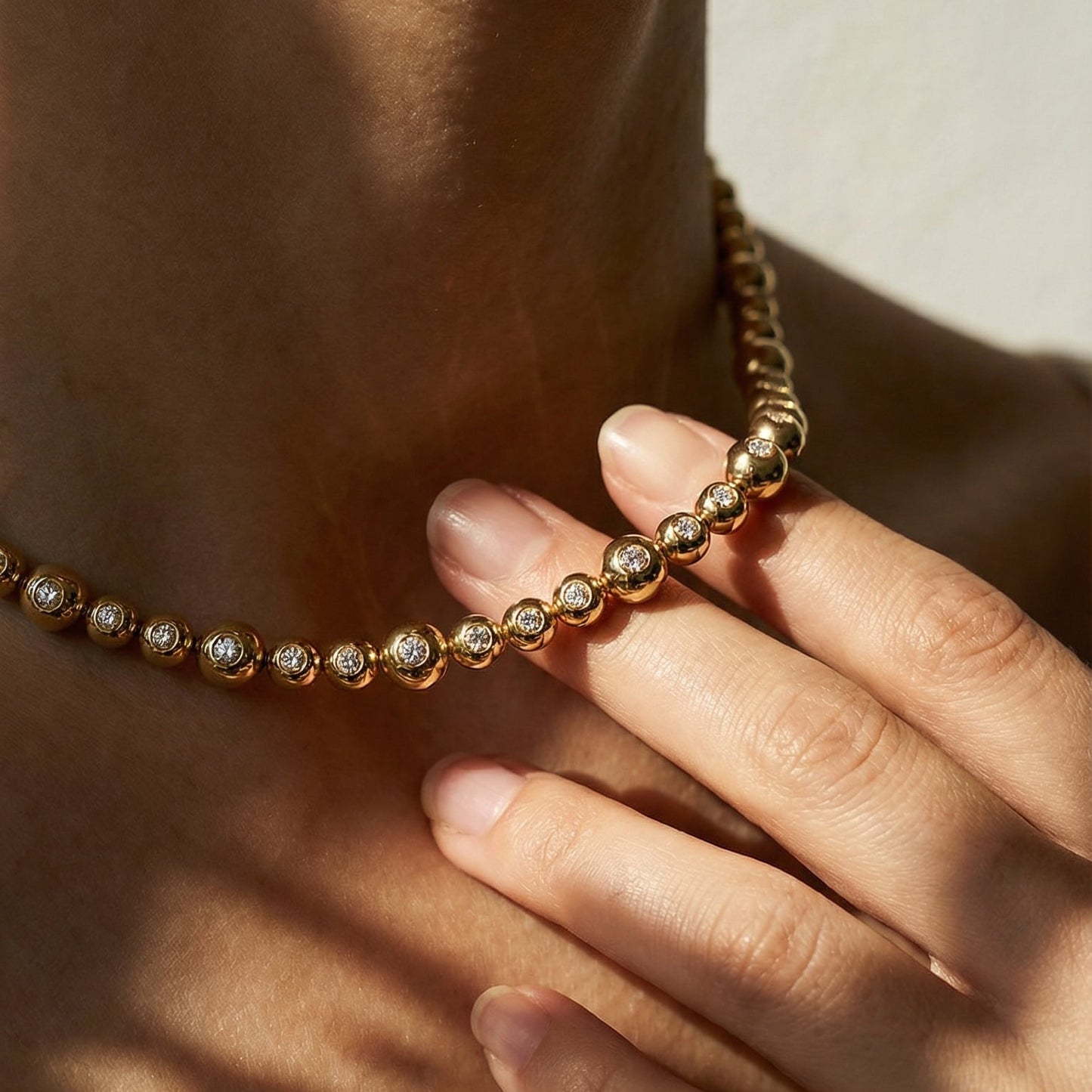 close up of a model wearring a yellow gold white diamond collier necklace