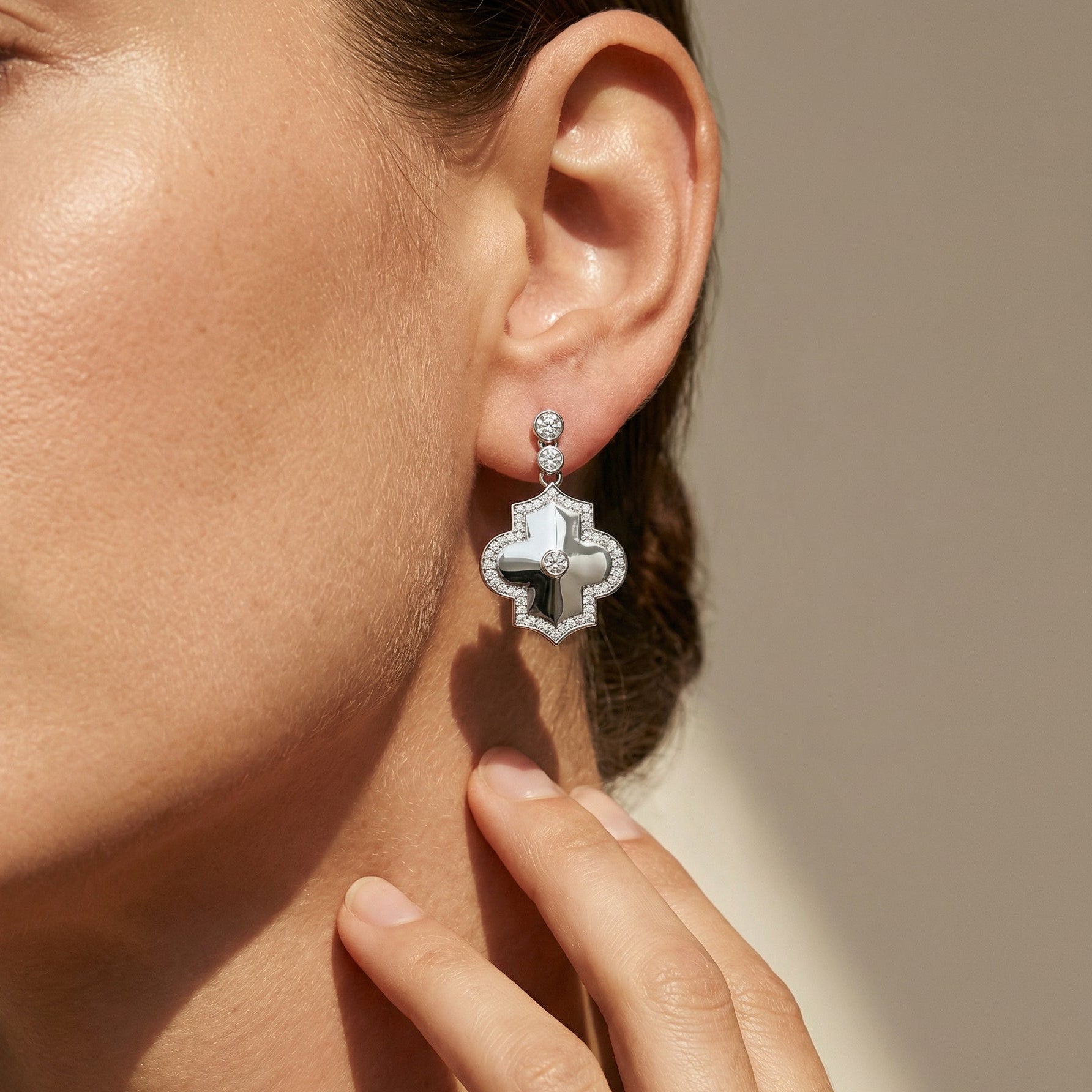 White gold white diamond geometrical shape drop earrings, close up image on a model 