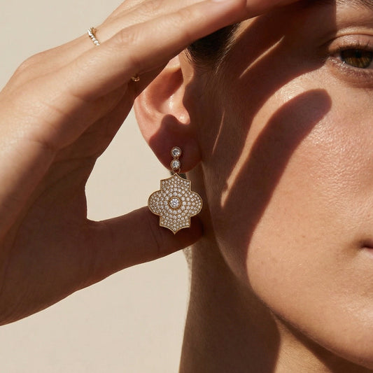 Close-up of a woman wearing a decorative earring with a neutral background