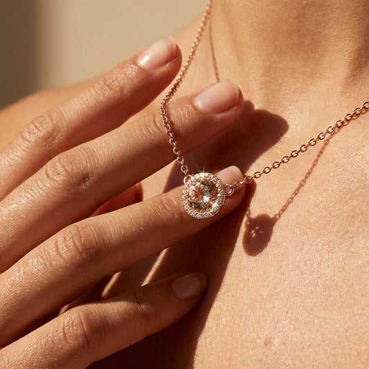 rose gold round pendant in peach morganite with diamond halo close up image on a model 