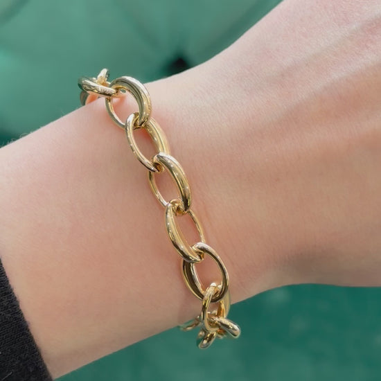 a gold bracelet on a models hand 