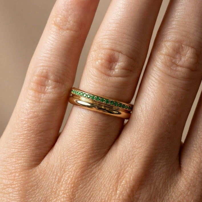yellow gold court shape ring with emerald stones full eternity band on models hand 