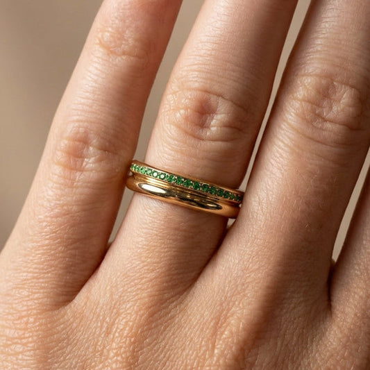 yellow gold court shape ring with emerald stones full eternity band on models hand 