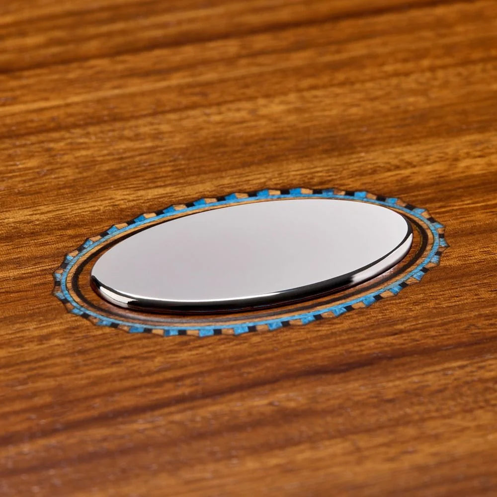 Metallic oval object with blue accents on a wooden surface